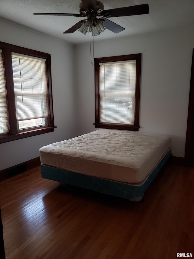 unfurnished bedroom featuring dark wood-type flooring and ceiling fan