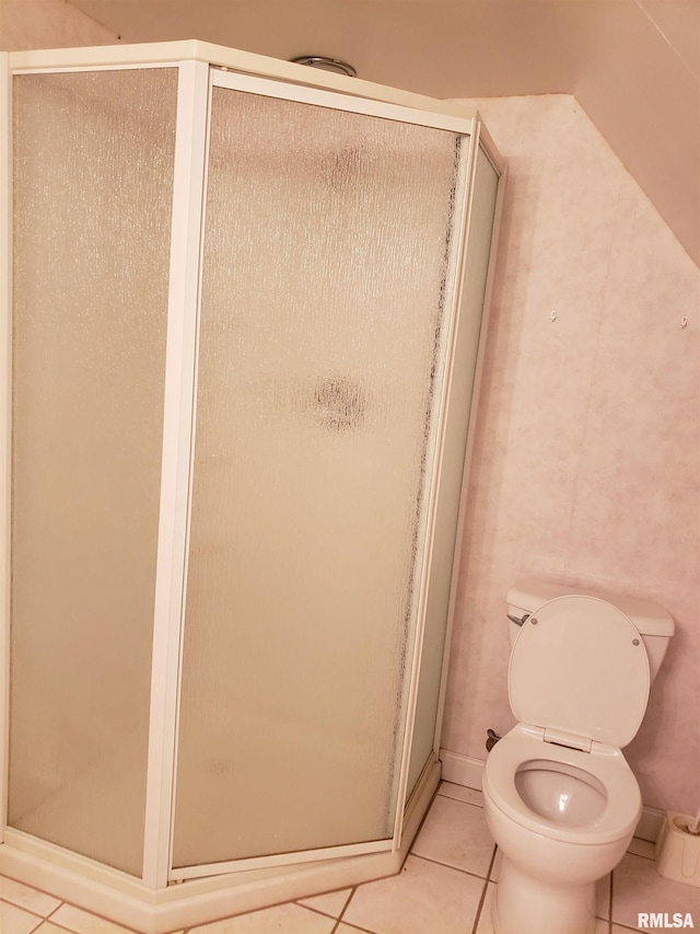 bathroom with toilet, a shower with door, and tile patterned flooring