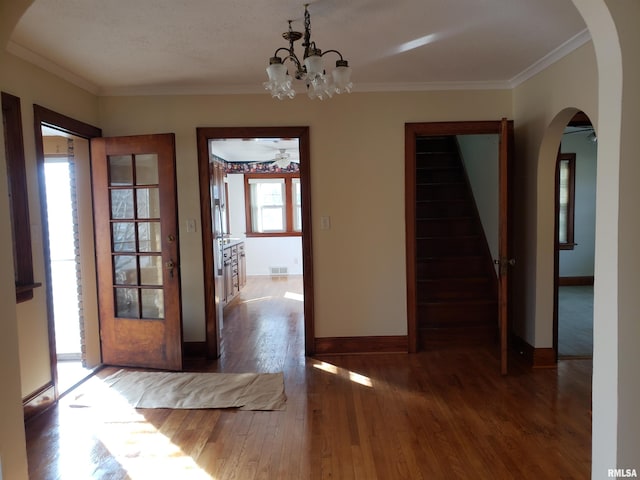 interior space featuring ornamental molding, dark hardwood / wood-style floors, and ceiling fan with notable chandelier