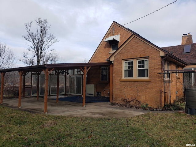 rear view of property featuring a patio area and a lawn