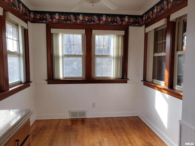 unfurnished dining area with ceiling fan and light hardwood / wood-style flooring