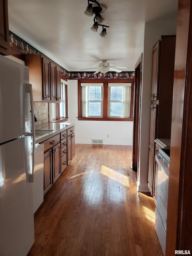 kitchen with ceiling fan, range, fridge, decorative backsplash, and light wood-type flooring