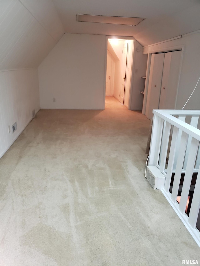 bonus room featuring vaulted ceiling and light colored carpet