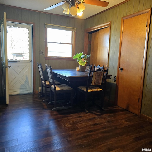 dining area featuring wooden walls, dark wood-type flooring, and crown molding