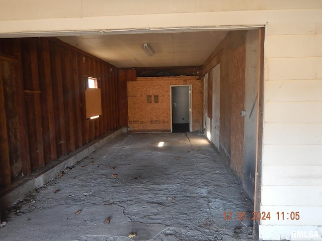 hallway featuring wooden walls