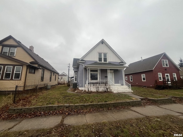 view of front of house with covered porch, central AC unit, and a front yard