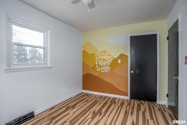 empty room with light wood-type flooring and ceiling fan