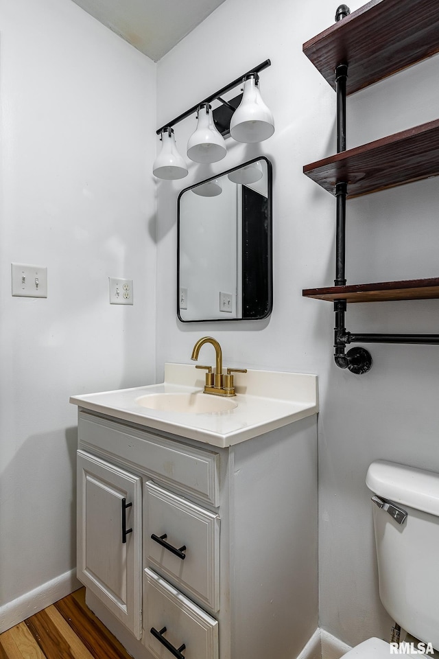 bathroom featuring vanity, wood-type flooring, and toilet