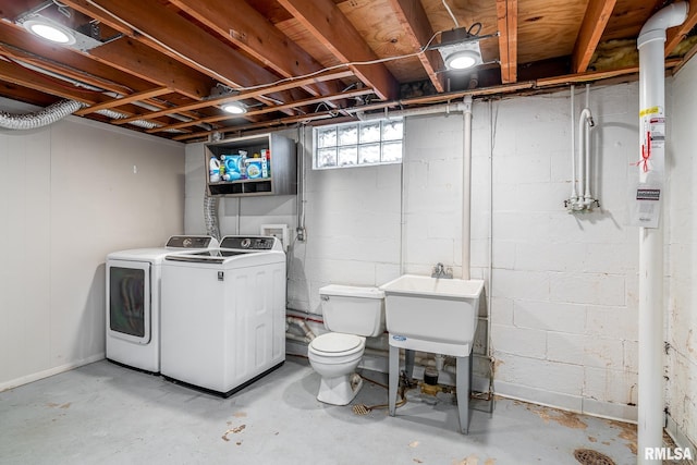 basement featuring washing machine and clothes dryer and sink