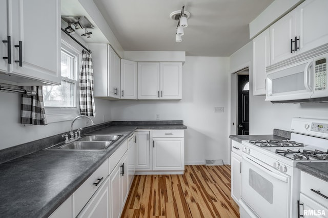 kitchen with white cabinetry, sink, and white appliances