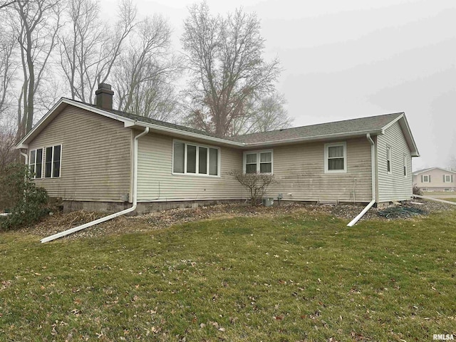 rear view of property featuring a yard