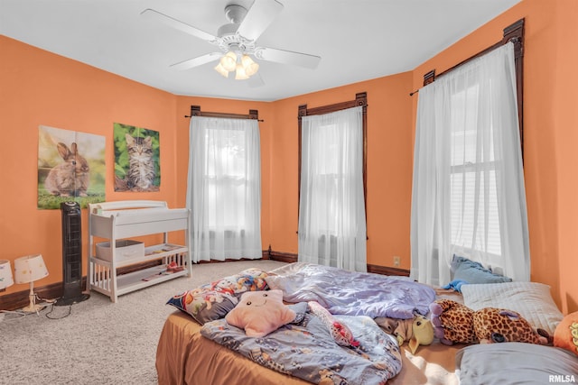 bedroom featuring carpet, ceiling fan, and multiple windows