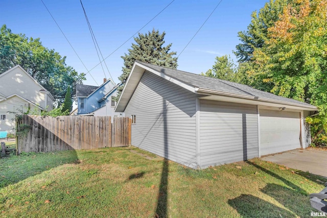 view of property exterior featuring a lawn, an outbuilding, and a garage