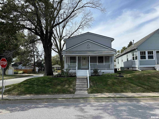 bungalow-style home featuring covered porch and a front yard