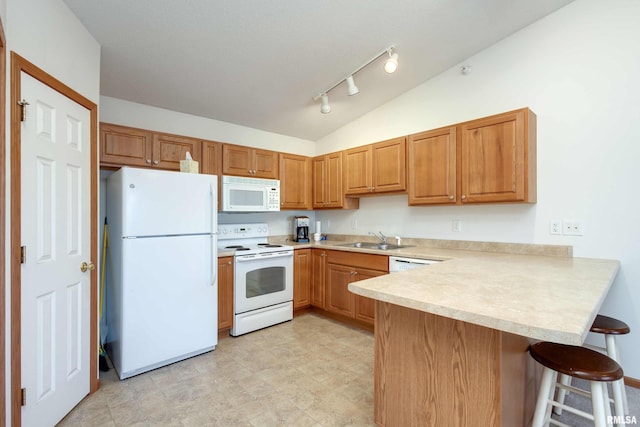 kitchen with a breakfast bar, white appliances, sink, vaulted ceiling, and kitchen peninsula