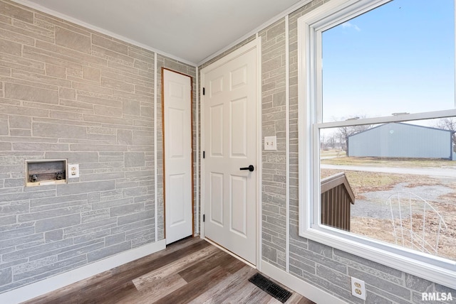 doorway featuring dark wood-type flooring and ornamental molding