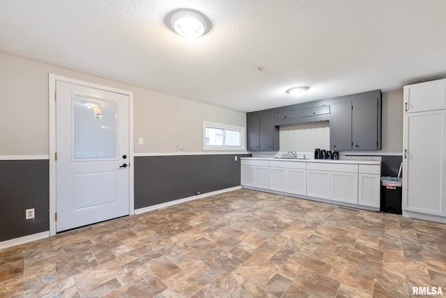 kitchen with white cabinetry, sink, and a textured ceiling