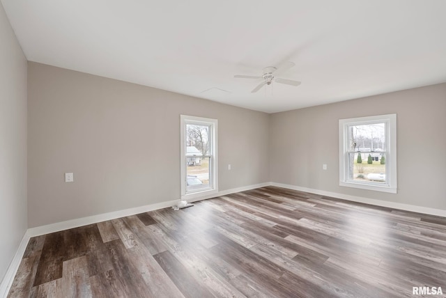 spare room featuring ceiling fan, wood-type flooring, and a wealth of natural light