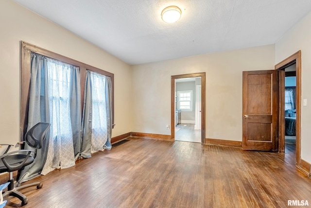 unfurnished office with a textured ceiling and hardwood / wood-style flooring