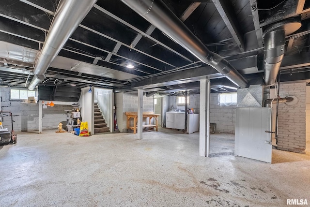 basement with washing machine and clothes dryer and heating unit