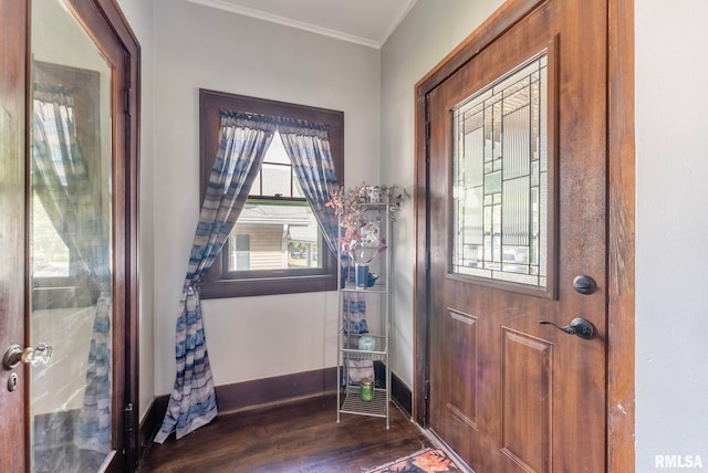 foyer entrance with ornamental molding and dark wood-type flooring