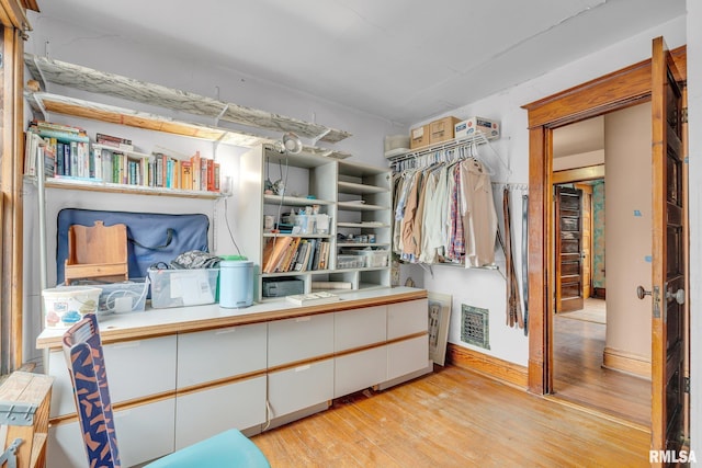 walk in closet with light hardwood / wood-style flooring