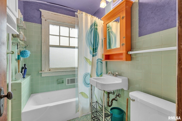 full bathroom featuring shower / tub combo with curtain, sink, tile walls, tile patterned flooring, and toilet