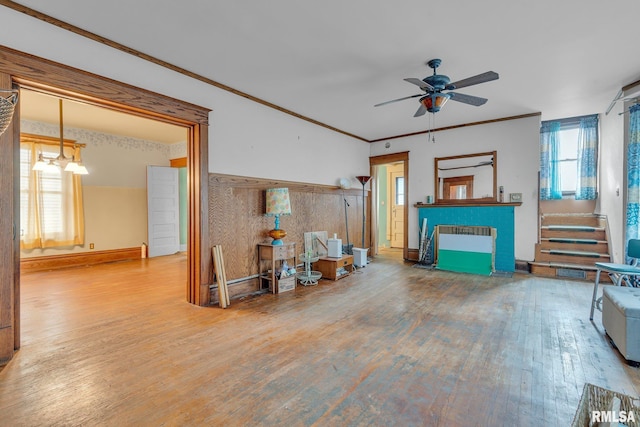 living room with crown molding, hardwood / wood-style floors, and ceiling fan with notable chandelier