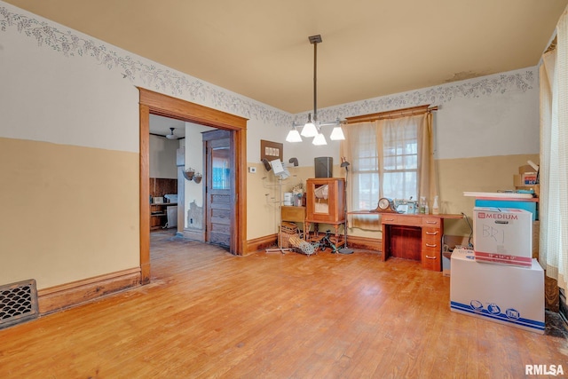 dining area with wood-type flooring and a notable chandelier