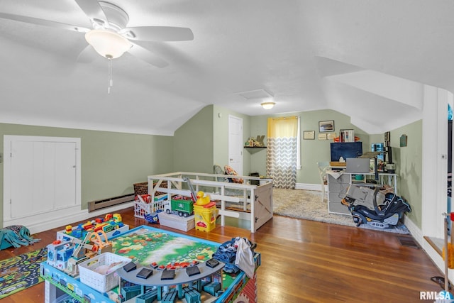 rec room with ceiling fan, hardwood / wood-style floors, vaulted ceiling, and a baseboard heating unit