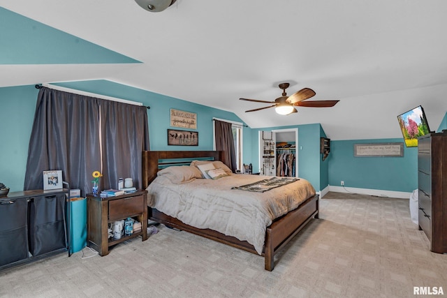 carpeted bedroom with ceiling fan, a walk in closet, lofted ceiling, and a closet