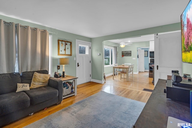 living room with ceiling fan and light hardwood / wood-style flooring