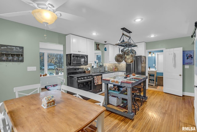 kitchen with white cabinetry, ceiling fan, decorative light fixtures, decorative backsplash, and black appliances