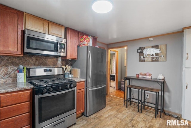 kitchen with backsplash, stainless steel appliances, light hardwood / wood-style flooring, and ornamental molding