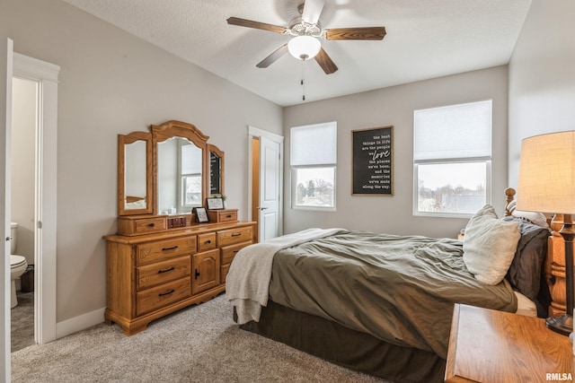 carpeted bedroom featuring a textured ceiling, connected bathroom, ceiling fan, and multiple windows