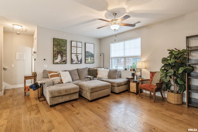 living room featuring a textured ceiling, light hardwood / wood-style flooring, and ceiling fan