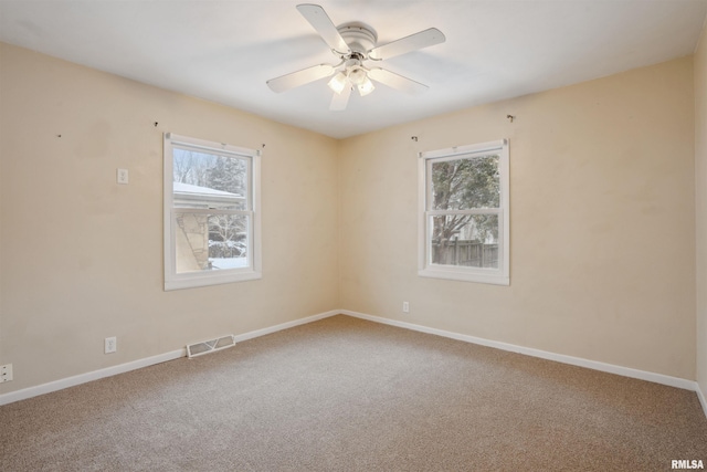 empty room with carpet floors, a wealth of natural light, and ceiling fan