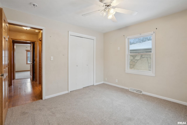 unfurnished bedroom with ceiling fan, a closet, and carpet