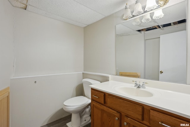 bathroom featuring a paneled ceiling, vanity, and toilet