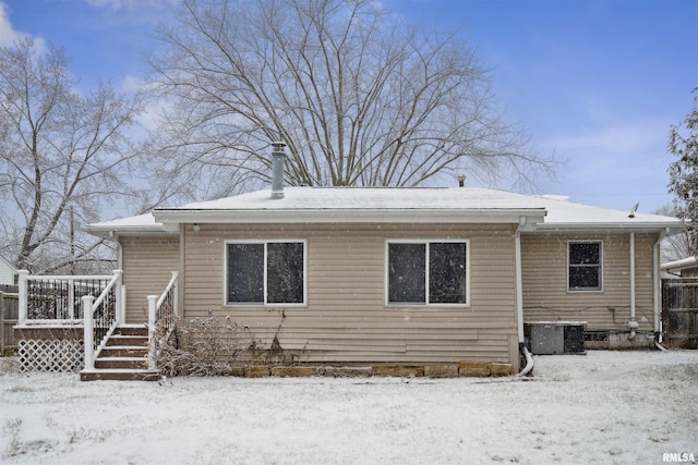 snow covered house with central AC unit