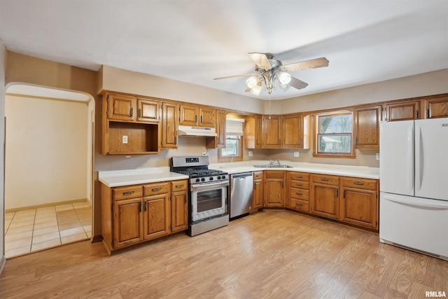 kitchen with stainless steel appliances, light hardwood / wood-style flooring, ceiling fan, and sink