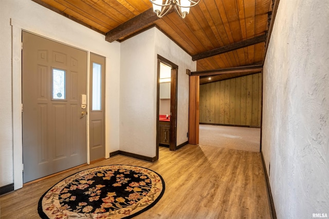 foyer featuring light hardwood / wood-style floors, beamed ceiling, wood ceiling, and an inviting chandelier