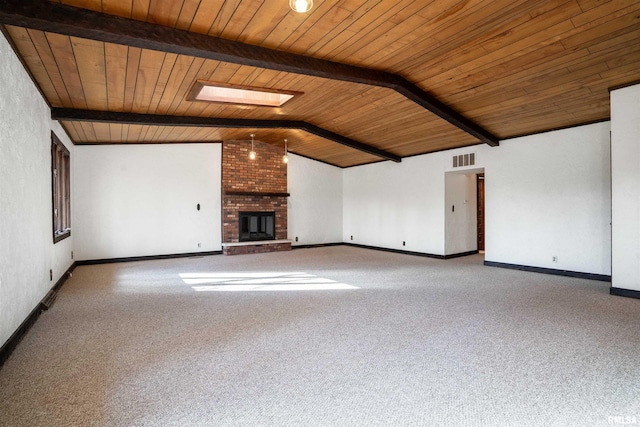 unfurnished living room with carpet flooring, a fireplace, vaulted ceiling with skylight, and wood ceiling