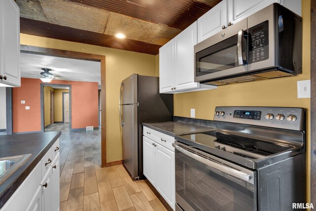 kitchen with wooden ceiling, ceiling fan, light hardwood / wood-style floors, white cabinetry, and stainless steel appliances