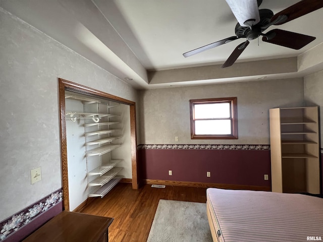 unfurnished bedroom with wood-type flooring, ceiling fan, and a closet