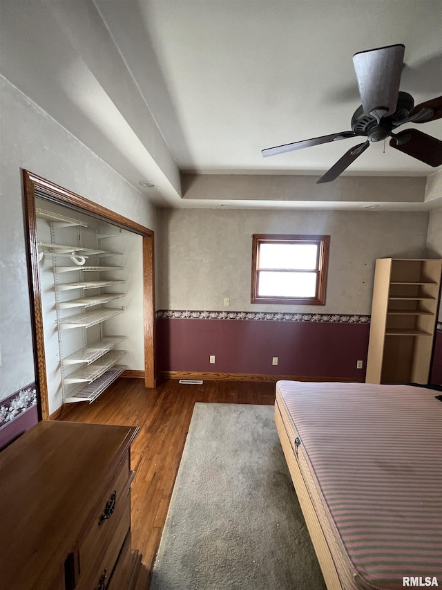 unfurnished bedroom with ceiling fan and dark hardwood / wood-style floors