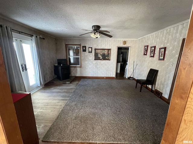 unfurnished living room featuring ceiling fan, ornamental molding, hardwood / wood-style floors, and a textured ceiling