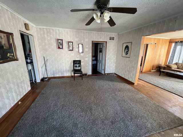 unfurnished room with crown molding, ceiling fan, dark wood-type flooring, and a textured ceiling