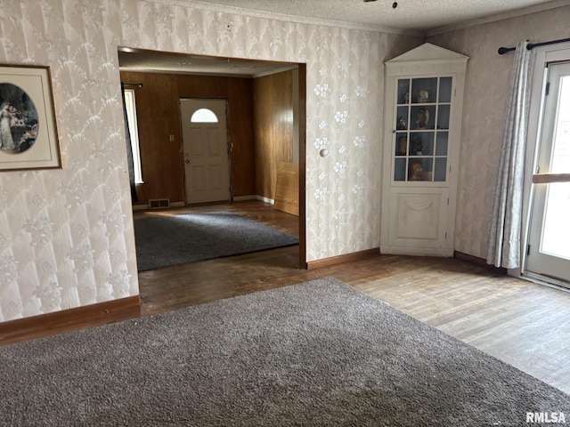 560 4th Ave S, Clinton, IA 52732 - foyer with wallpapered walls, wood finished floors, healthy amount of natural light, baseboards, and a textured ceiling