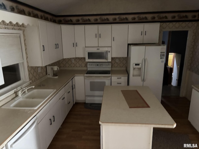 560 4th Ave S, Clinton, IA 52732 - kitchen featuring white appliances, a sink, white cabinets, dark wood-style flooring, and a center island